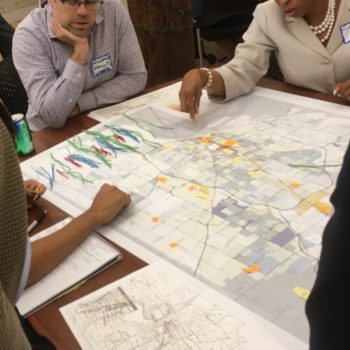 People doing a network planning exercise around a map of their city.
